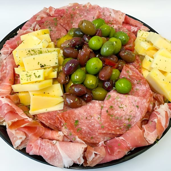A deli platter with sliced meats, cheeses, and a mix of green and black olives.